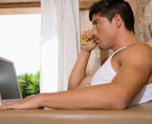 Man in front of laptop holding a card